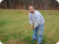 Probing the ground to locate a septic system's drain field.